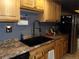 Kitchen features wood cabinets, double sink, and granite countertops at 3550 S Harlan St # 313, Denver, CO 80235
