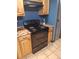Updated kitchen with black appliances and wood cabinets at 3550 S Harlan St # 313, Denver, CO 80235