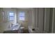 Updated bathroom with white vanity, bathtub, and wood-look floors at 1940 Quince St, Denver, CO 80220