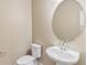 Clean and modern powder room with pedestal sink and round mirror at 21278 E 63Rd Dr, Aurora, CO 80019