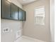 Laundry room with dark green cabinets and window at 21278 E 63Rd Dr, Aurora, CO 80019