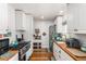 Updated kitchen featuring white cabinets, wood countertops, and stainless steel appliances at 1160 S Monroe St, Denver, CO 80210