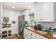 Modern kitchen with white cabinets, butcher block countertops, and teal appliances at 1160 S Monroe St, Denver, CO 80210