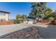 Landscaped backyard with gravel pathway, mature trees, and detached garage at 1160 S Monroe St, Denver, CO 80210
