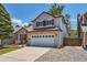 Charming two-story home with a gray and red exterior and attached two-car garage at 9823 Foxhill Cir, Highlands Ranch, CO 80129