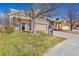 Two-story house with a beige and green exterior, attached garage, and landscaping at 7306 S Nucla St, Aurora, CO 80016