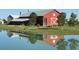 Community barn with pond reflection; a charming centerpiece at 10912 Memphis Ct, Commerce City, CO 80022