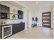 Stylish entryway with contemporary built-in bar, wine cooler, and wood flooring at 9737 Majestic Oak Dr, Parker, CO 80134