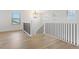 Upstairs landing with hardwood floors and a modern railing at 42992 Colonial Trl, Elizabeth, CO 80107