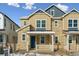 Tan two-story home with stone accents, covered porch, and snowy landscape at 8663 Snake River St, Littleton, CO 80125