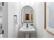 Modern powder room with a stylish pedestal sink and arched mirror at 16514 W 93Rd Way, Arvada, CO 80007
