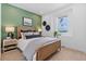 Tranquil bedroom with a green accent wall, comfortable bed, and natural light from the window at 16514 W 93Rd Way, Arvada, CO 80007