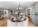 Modern dining area with a stylish chandelier, round table, and a view of the kitchen at 16514 W 93Rd Way, Arvada, CO 80007