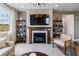 Modern fireplace with a wood mantel, tile surround, and built-in shelving at 16514 W 93Rd Way, Arvada, CO 80007