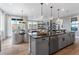Kitchen island with dark countertop, gray cabinets, and a view of the dining and living area at 16514 W 93Rd Way, Arvada, CO 80007