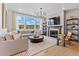 Cozy living room with a fireplace, wood floors, and large windows at 16514 W 93Rd Way, Arvada, CO 80007
