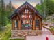 Exterior view of a stunning log home nestled in a wooded area at 1003 Boreas Pass Rd, Breckenridge, CO 80424