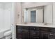 Bright bathroom with dual vanity, white tile, and dark wood cabinets at 1785 Marlowe E Cir, Erie, CO 80516