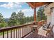 Peaceful deck overlooking the wooded area with seating for two at 115 Spruce Rd, Golden, CO 80401