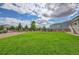 Large grassy backyard with a partially visible house and wooden fence at 4864 Harness Ct, Parker, CO 80134