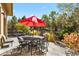 Patio furniture under a red umbrella, next to a water feature at 6297 Ellingwood Point Way, Castle Rock, CO 80108