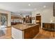 Open kitchen with granite island, stainless steel appliances, and views to living room at 6297 Ellingwood Point Way, Castle Rock, CO 80108