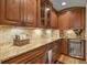 Butler's pantry with granite countertops and custom wood cabinetry at 6297 Ellingwood Point Way, Castle Rock, CO 80108
