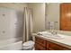 Clean bathroom with a tub, toilet, and vanity with wood cabinets at 6297 Ellingwood Point Way, Castle Rock, CO 80108