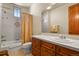 Clean bathroom with a tub, toilet, and vanity with wood cabinets at 6297 Ellingwood Point Way, Castle Rock, CO 80108