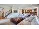 Open living room with sectional sofa, ottoman, and views of the kitchen at 2272 Front Range Rd, Erie, CO 80516