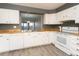White kitchen cabinets and wood countertops, with a view into the adjacent living space at 7900 W Layton Ave # 833, Littleton, CO 80123