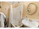 Elegant bathroom with a clawfoot tub, white sink, and gold fixtures at 27425 Spruce Ln, Evergreen, CO 80439