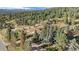 Aerial view of the property and surrounding neighborhood nestled in the mountains at 27425 Spruce Ln, Evergreen, CO 80439