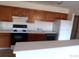 Kitchen with wood cabinets, stove, and refrigerator at 12043 W Cross Dr # 201, Littleton, CO 80127