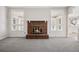 Living room with a brick fireplace, large windows, and gray carpeting at 1151 S Nome St, Aurora, CO 80012