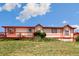House exterior showcasing a beige house with red accents and a wooden deck at 12155 Mesa View Rd, Larkspur, CO 80118