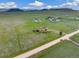 Aerial view of a property showing a house, a detached garage, and a long driveway at 12155 Mesa View Rd, Larkspur, CO 80118