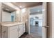 Clean bathroom with a vanity, toilet and view into kitchen at 12983 W Ida Ave # 107 Ada Type A, Littleton, CO 80127