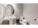 Powder room with pedestal sink, toilet, and circular mirror at 811 Horizon Ct, Erie, CO 80516