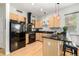 Modern kitchen with black appliances, light wood cabinets, and granite counters at 1438 Little Raven St # 102, Denver, CO 80202