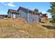 Two-story house with blue siding, red trim, and deck at 3188 S County Road 137, Bennett, CO 80102