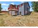 Two-story house with blue siding, red trim, and elevated deck at 3188 S County Road 137, Bennett, CO 80102