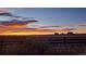 Beautiful sunset over fields with distant houses and a wooden fence in the foreground at 3188 S County Road 137, Bennett, CO 80102