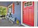 Front porch with red door and metal chicken decor at 3188 S County Road 137, Bennett, CO 80102