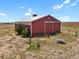 Large red barn with a metal roof and large doors at 3188 S County Road 137, Bennett, CO 80102