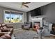 Bright living room with a fireplace, large window, and comfortable seating at 3188 S County Road 137, Bennett, CO 80102