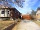 Side view of the house showcasing the brick exterior, driveway, and a wooden gate leading to the backyard at 1067 E 111Th Pl, Northglenn, CO 80233