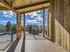 Covered deck with wooden beams and railings, overlooking the neighborhood and distant mountains at 3534 Running Deer Dr, Castle Rock, CO 80109