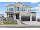 Two-story house with gray siding, black garage doors, and a landscaped front yard at 1136 Hillside Ln, Louisville, CO 80027