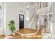 Bright and airy entryway with hardwood floors, a staircase, and a large ficus tree at 9572 Desert Willow Way, Highlands Ranch, CO 80129